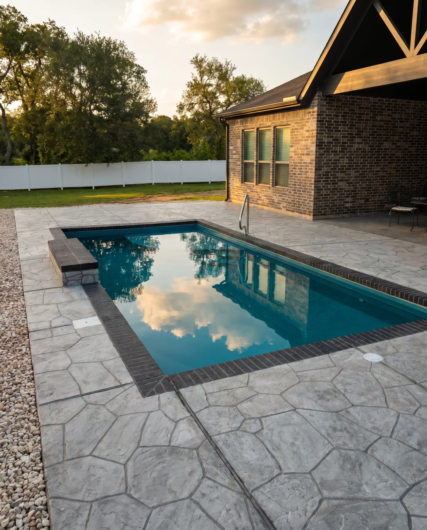 Real Kinetic modern rectangular fiberglass pool with a stamped concrete deck